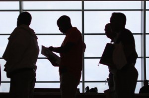 People looking for work stand in line at a job fair at the Miami. Millions will lose their federal unemployment benefits this month. ( Joe Raedle/Getty Images)